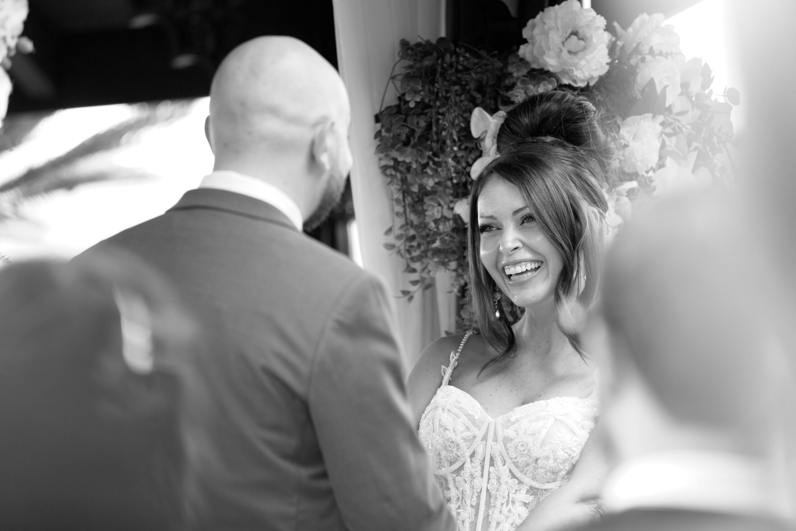 A bride and groom share a laugh during ceremony at Villa Botanica.