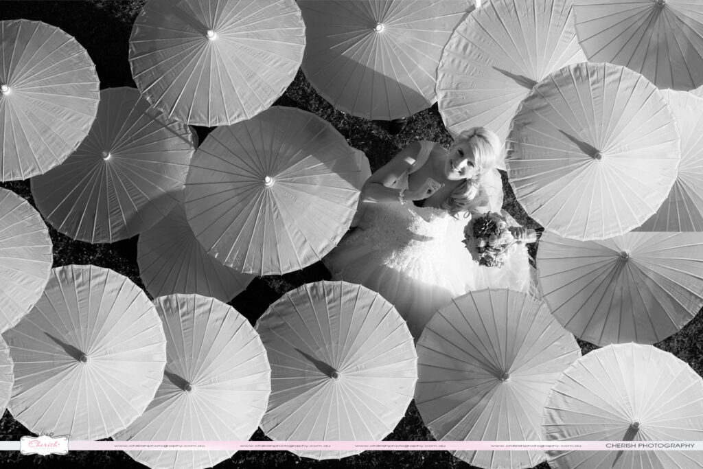 Creative wedding photography of bride in Airlie Beach with umbrellas.